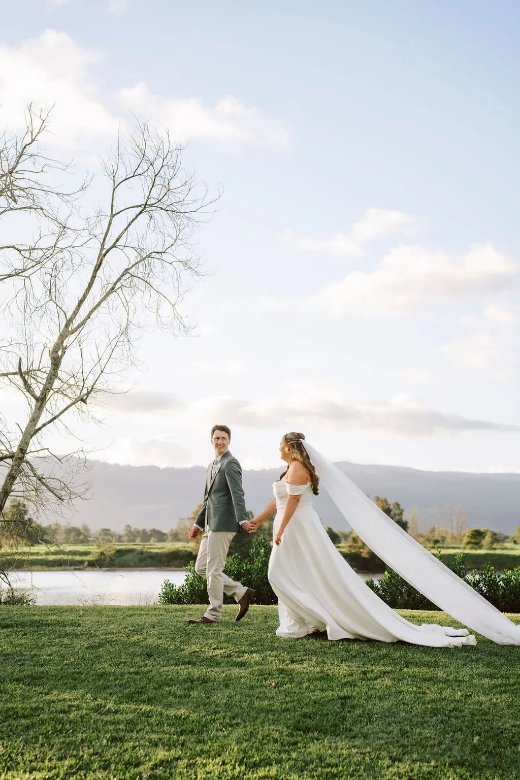 Bride and groom under the rose garden arch