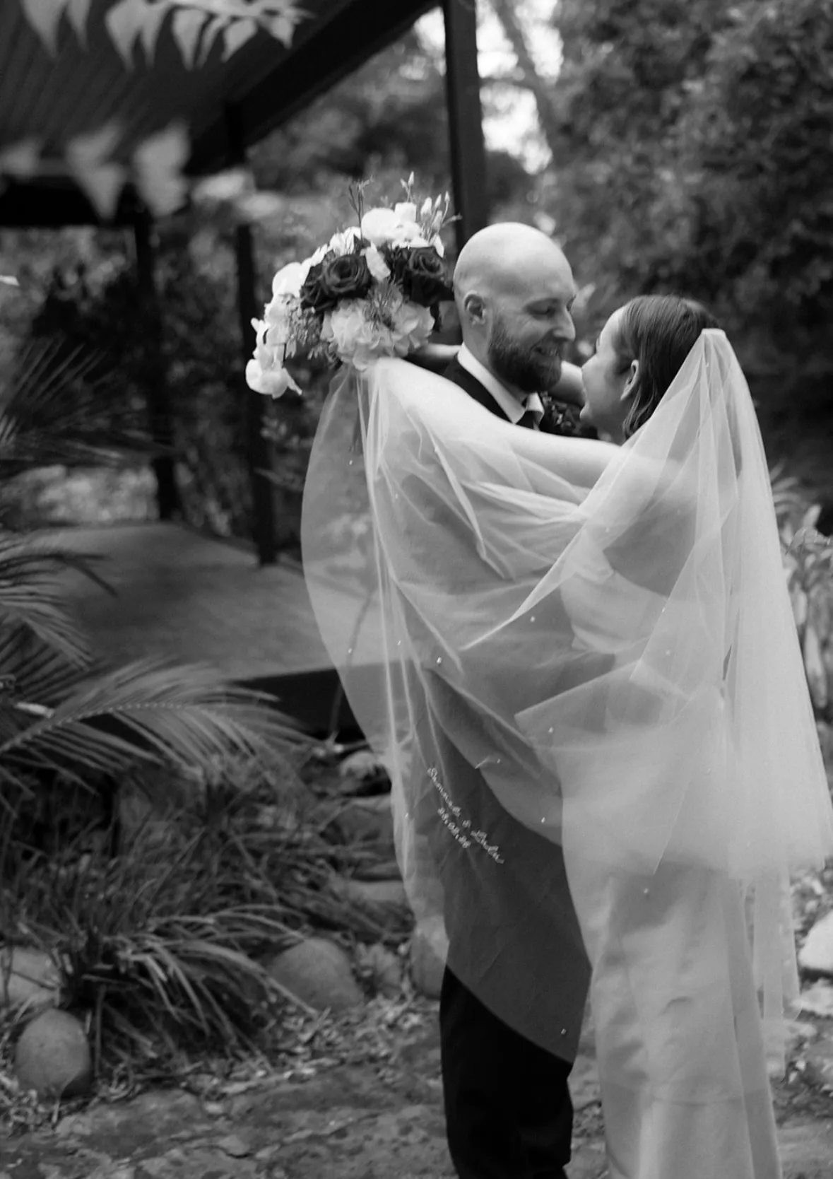 Bride and groom black and white photo with veil