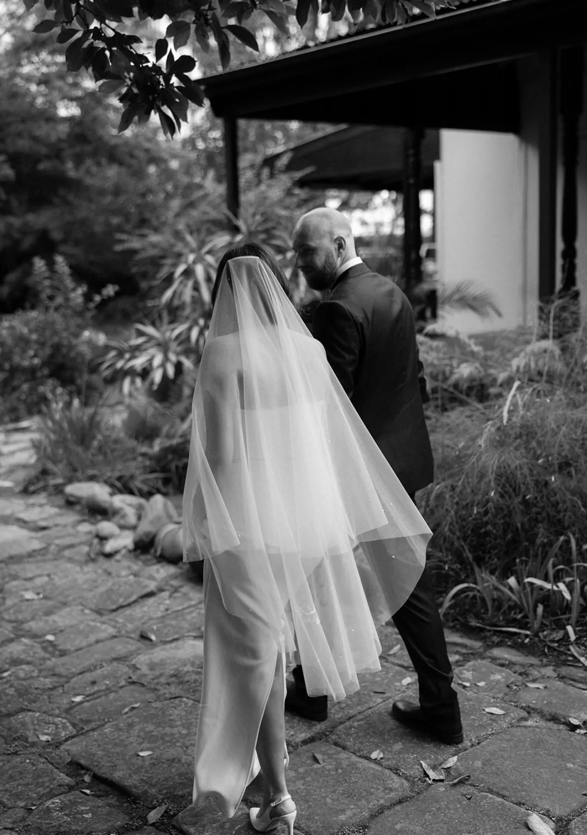 Black and white photo of bride and groom with veil