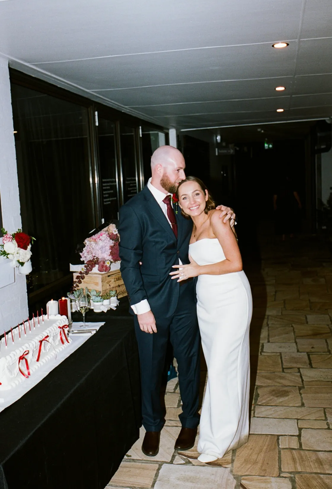 Bride and groom posing with cake
