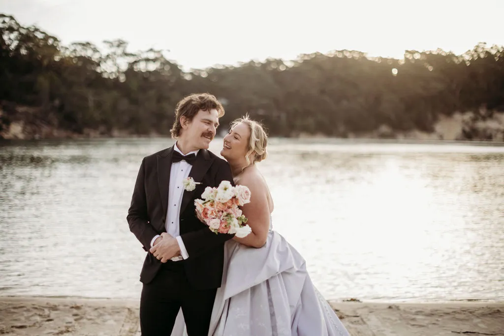 Bride and groom posing on the beach at The Cove Jervis Bay