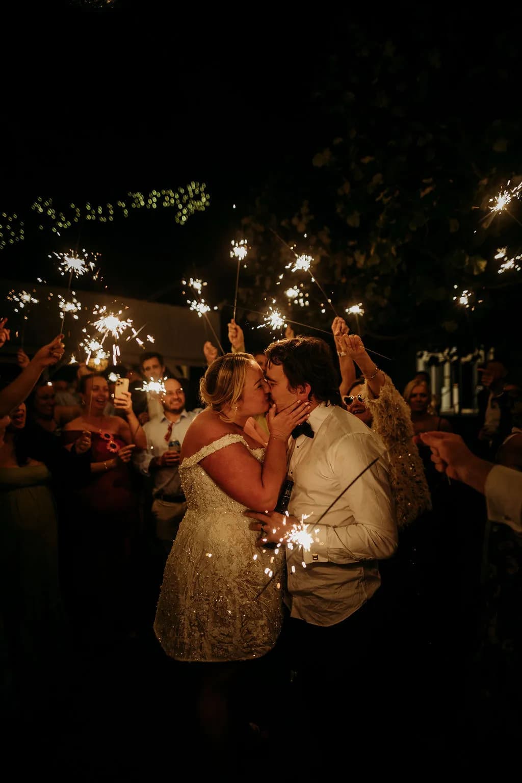 Bride and groom kissing with sparklers at The Cove Jervis Bay