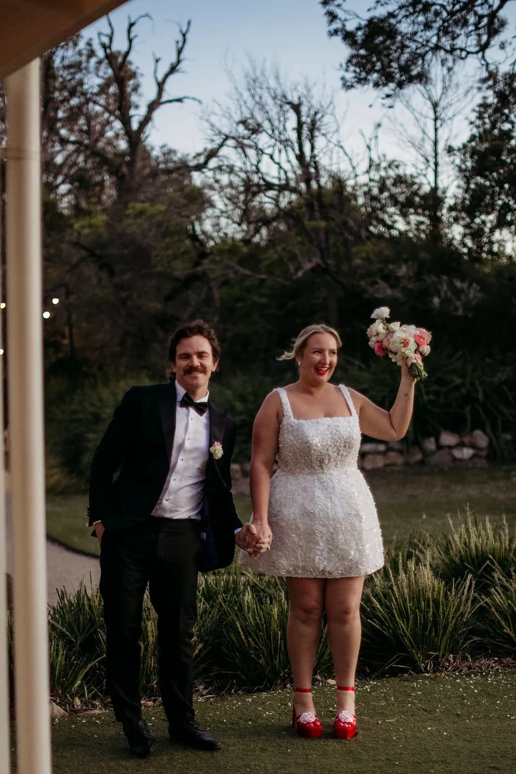 Bride and groom posing with bouquet at The Cove Jervis Bay