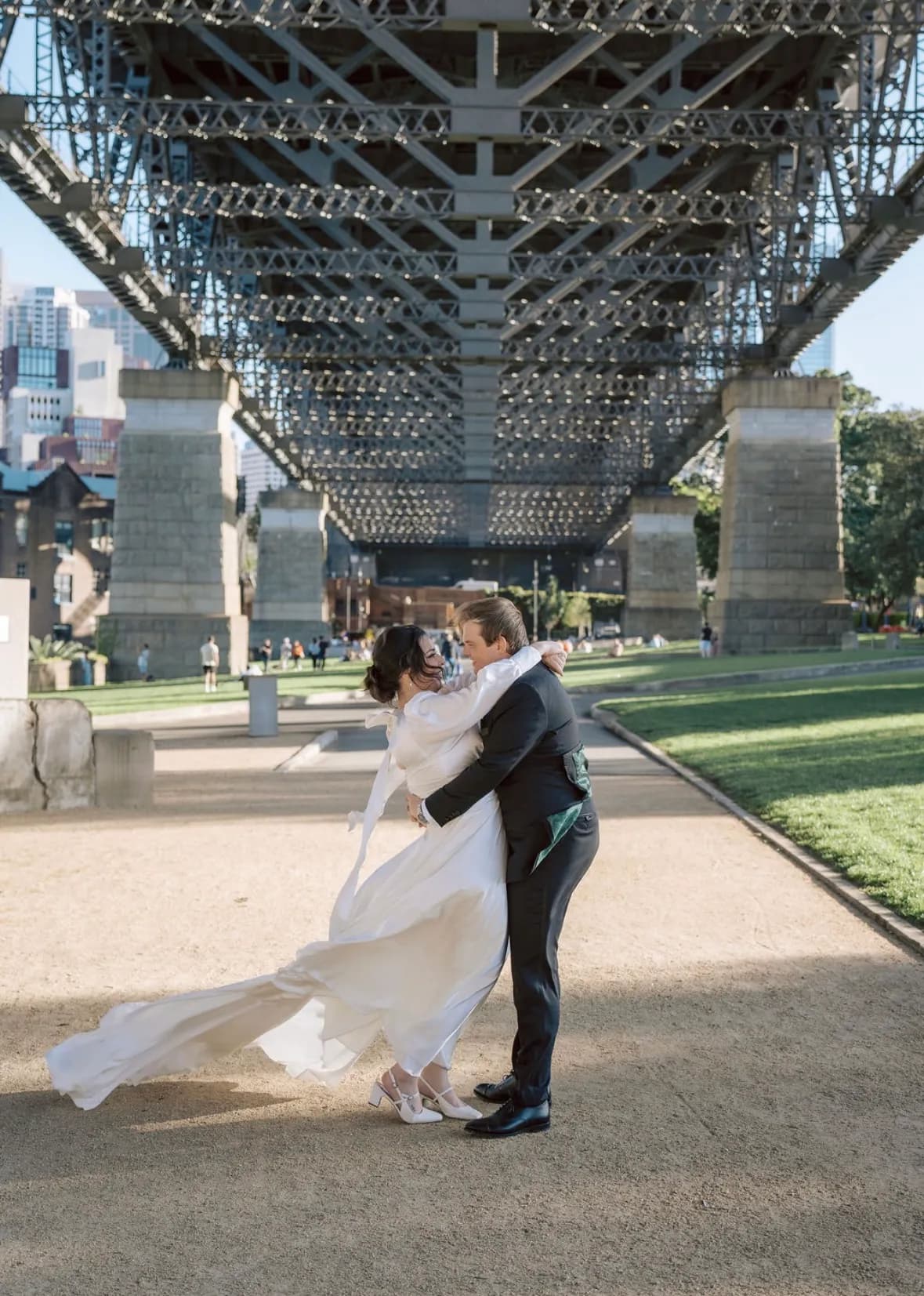 Bride and groom embracing under Sydney Harbour Bridge